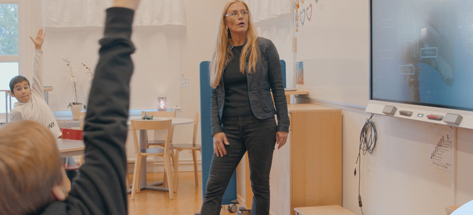 Visar en lärare inför en klass med en smartboard
