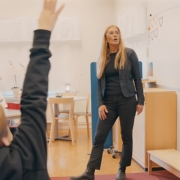 lärare med klass bilden visar en lädrae som utbildar elever med en smartboard